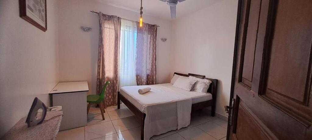 a small bedroom with a bed and a window at Bamburi One Bedroom Apartment in Mombasa