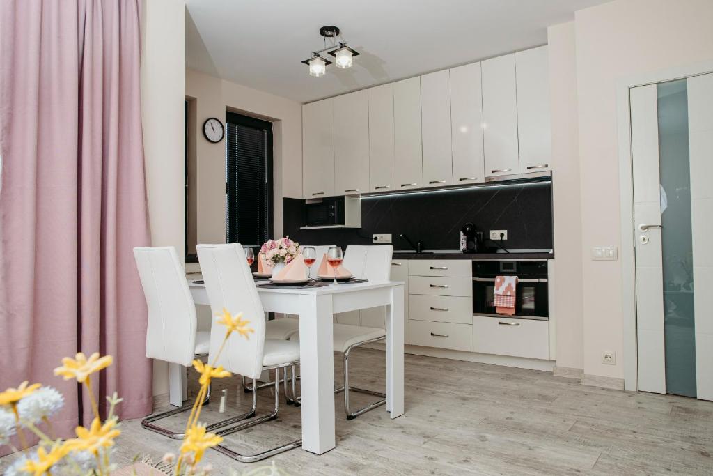 cocina con mesa blanca y sillas blancas en Rose Valley apartment en Kazanlŭk