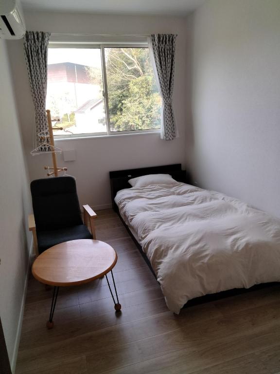 a bedroom with a bed and a chair and a table at Guesthouse Senba - Vacation STAY 16626 in Mito