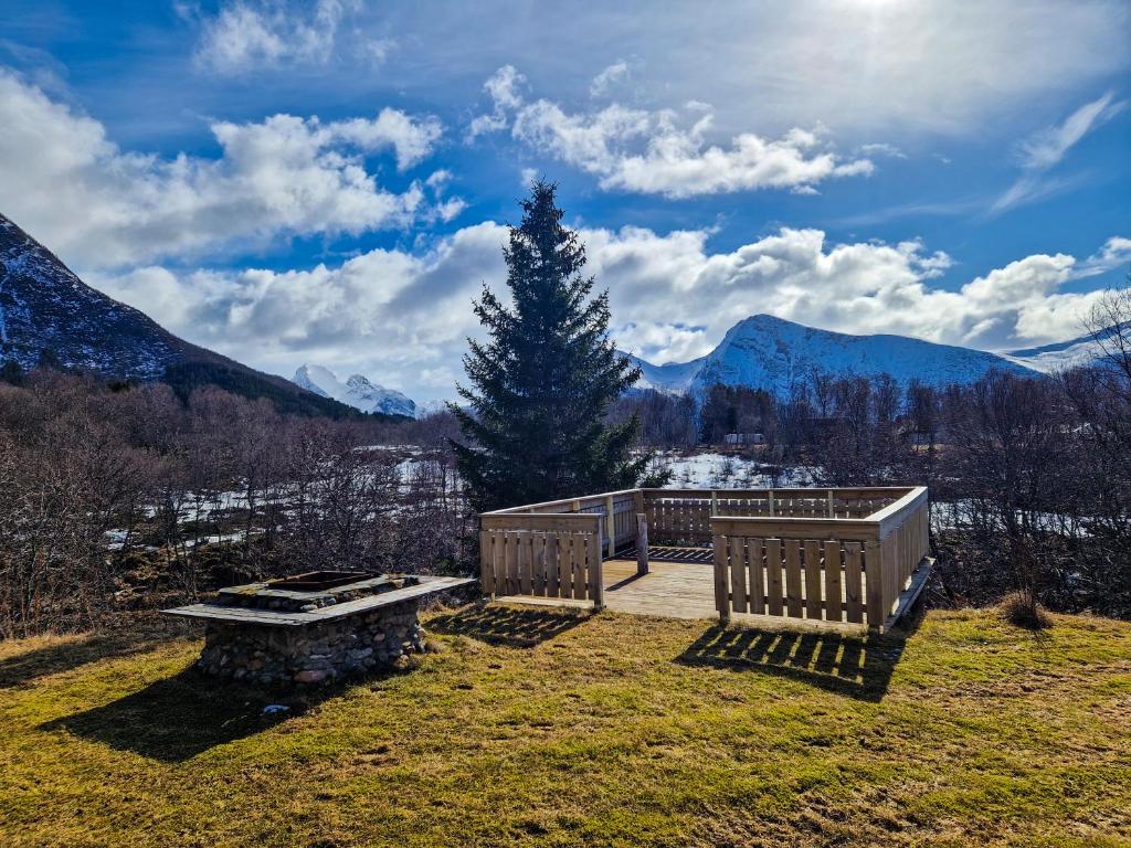 a bench on a field with mountains in the background at Happy Camper Living in Sortland