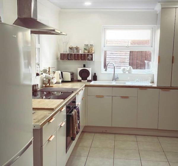 a kitchen with white cabinets and a sink and a window at The Nook House in Liverpool