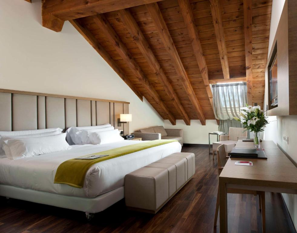 een slaapkamer met een groot bed en een houten plafond bij NH Collection Madrid Palacio de Tepa in Madrid