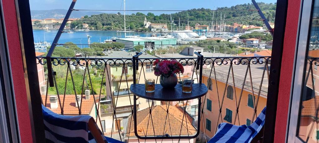 a balcony with a table with a vase of flowers at Una finestra sul Golfo di Le Grazie in Le Grazie