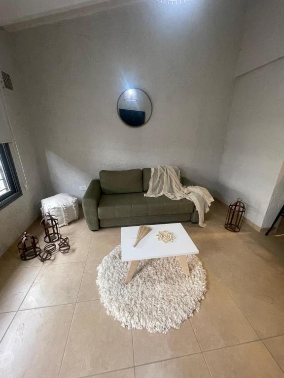 uma sala de estar com um sofá verde e uma mesa em El trébol em Tunuyán