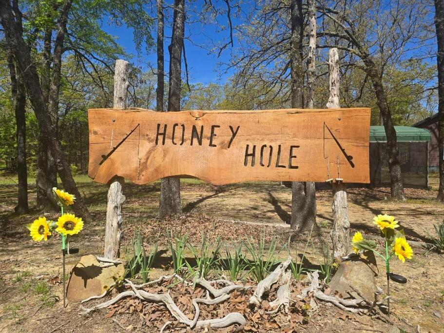 un cartello di legno che legge "buco del miele" nel bosco. di Glamper's Dream - Lakefront Cabin with Mountain View a Clayton