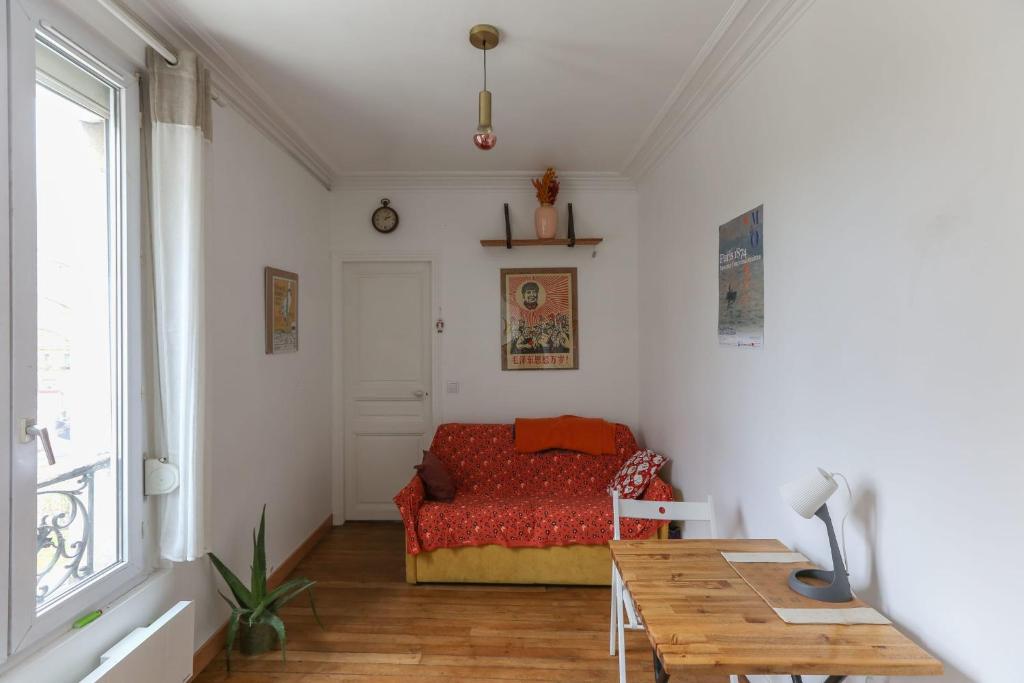 een kleine kamer met een bed en een tafel bij Cozy two-room apartment in Montreuil in Montreuil
