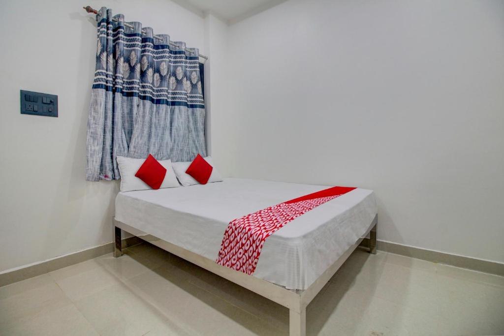 - un lit avec des oreillers rouges dans l'établissement OYO Flagship Hotel Roman Inn, à Nagpur