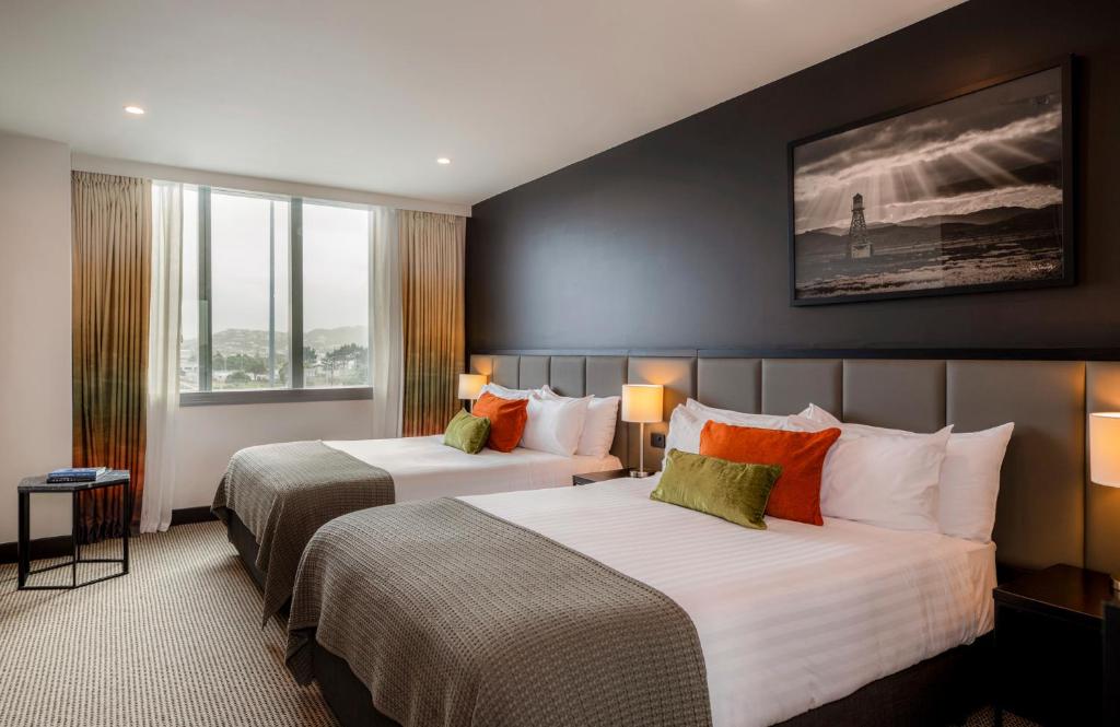 a hotel room with two beds and two windows at Rydges Wellington Airport in Wellington