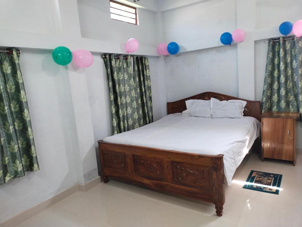 FarakkaにあるSolomile Homestayのベッドルーム1室(ピンクとブルーの風船が備わるベッド1台付)