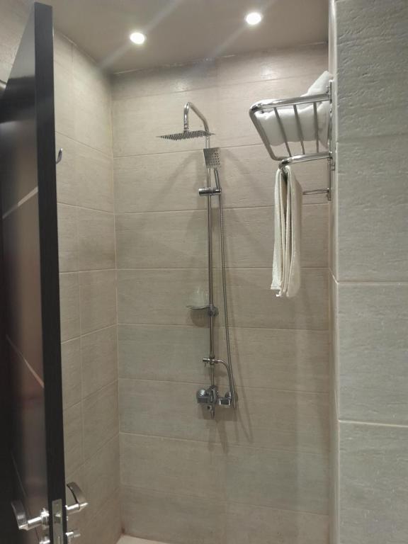 um chuveiro com uma porta de vidro na casa de banho em Coast Hotel em El Alamein