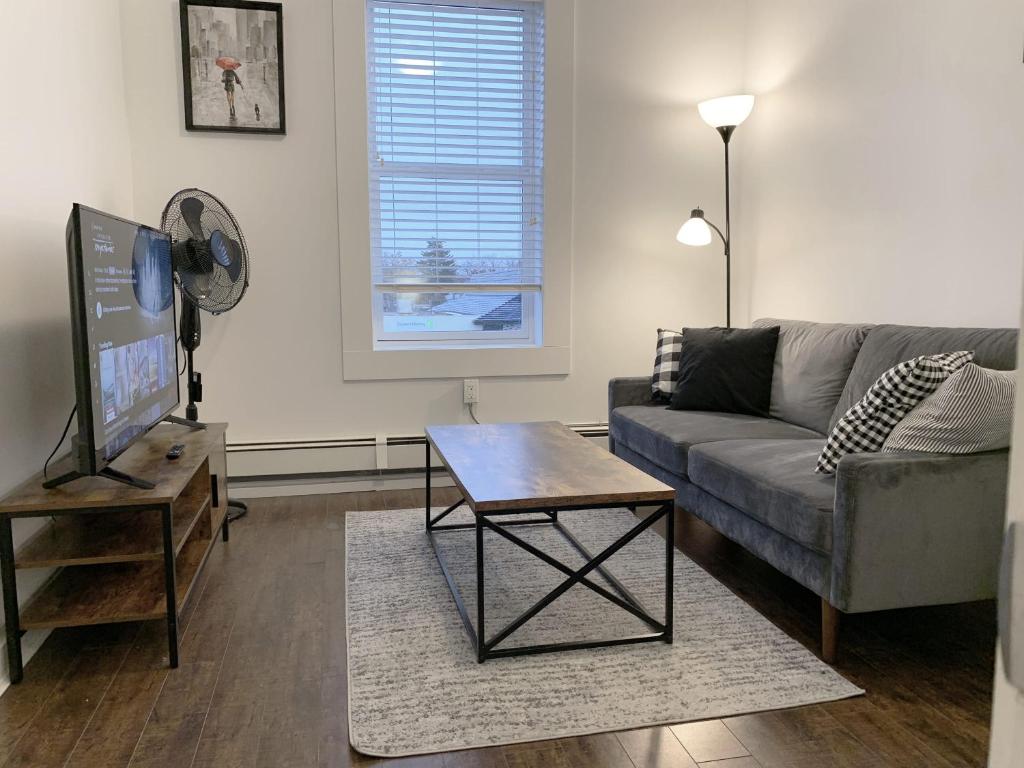 a living room with a couch and a table at Gorgeous 1-bedroom Condo Location WiFi in Moose Jaw