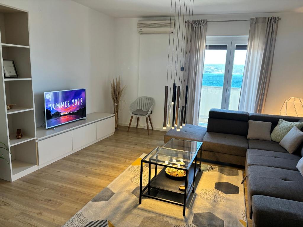 a living room with a couch and a tv at Apartments Del Mare in Crikvenica
