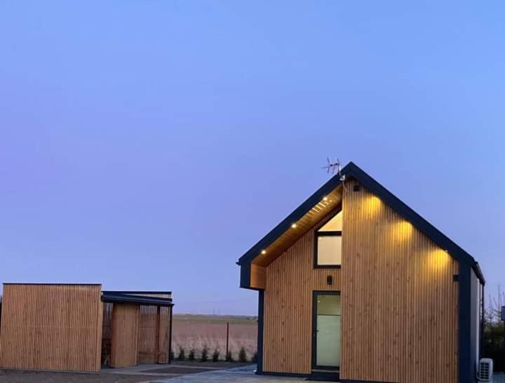 ein Holzhaus mit Lichtern darüber in der Unterkunft Klimatyzowany domek letniskowy in Mielno