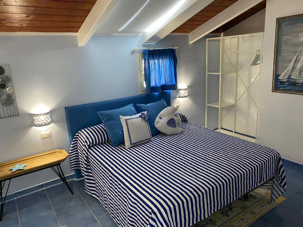 ヴィーコ・エクエンセにあるLa Torrettaのベッドルーム1室(青と白のストライプのベッド1台付)