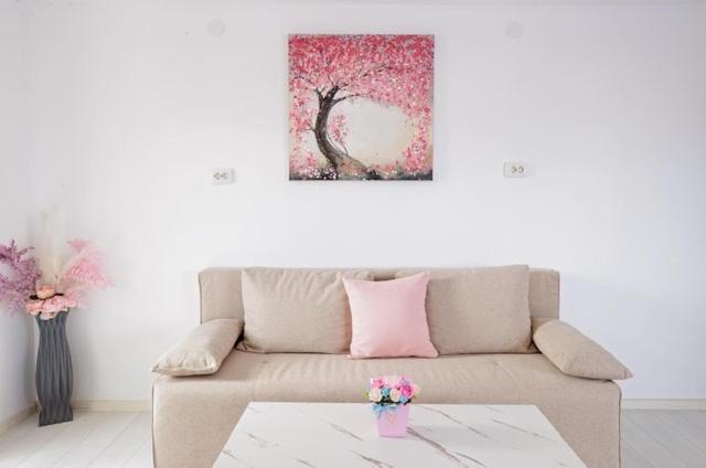 a living room with a couch and a painting on the wall at WhiteBoxApartment in Kyustendil
