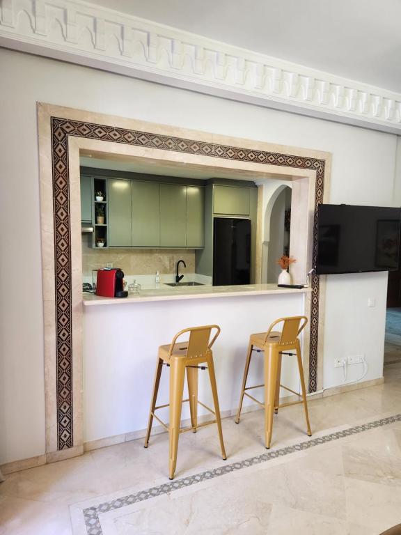 een spiegel voor een keuken met twee krukken bij Charmant appartement in Marrakesh