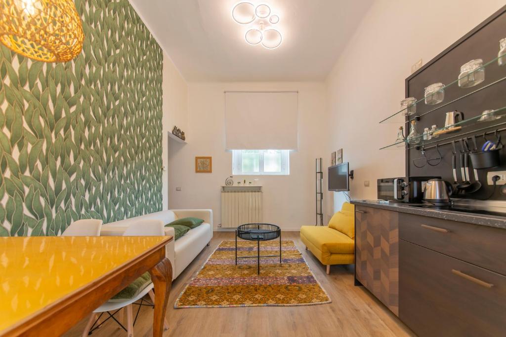 eine Küche und ein Wohnzimmer mit einem Sofa und einem Tisch in der Unterkunft Home Sweet Home in Rho