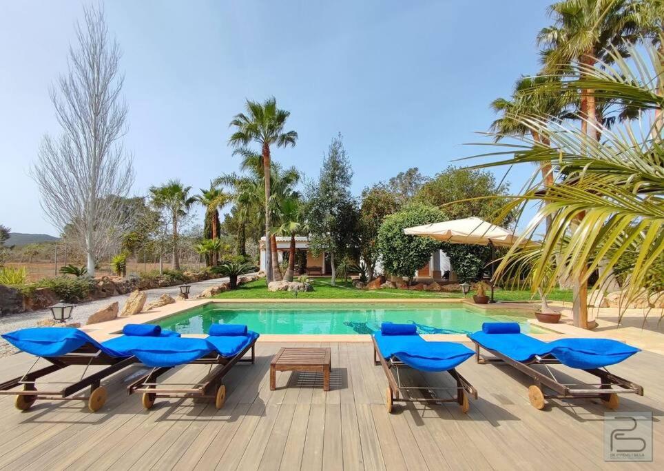 una piscina con tumbonas azules y una piscina en Casa Bet con piscina y jardín., en Sant Miquel de Balansat