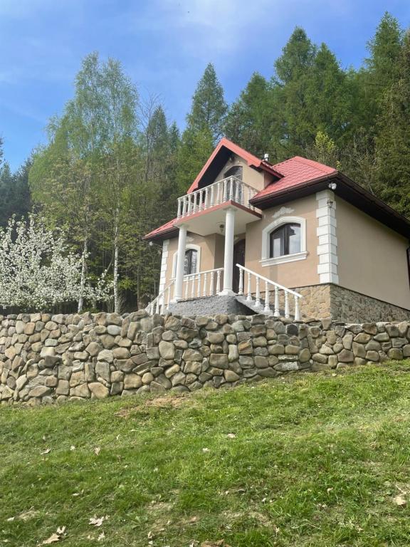 a house on a stone wall with a fence at Magurska enklawa- domek letniskowy in Nowy Żmigród