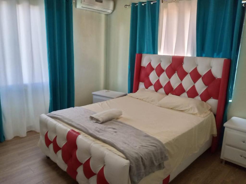 um quarto com uma cama vermelha e branca com cortinas azuis em Villa Esperanza em Buena Vista