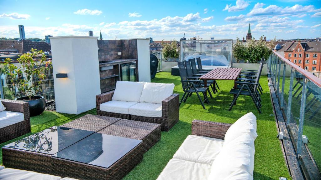 a patio with chairs and a table on a balcony at Luxury Penthouse in the heart of the City in Copenhagen