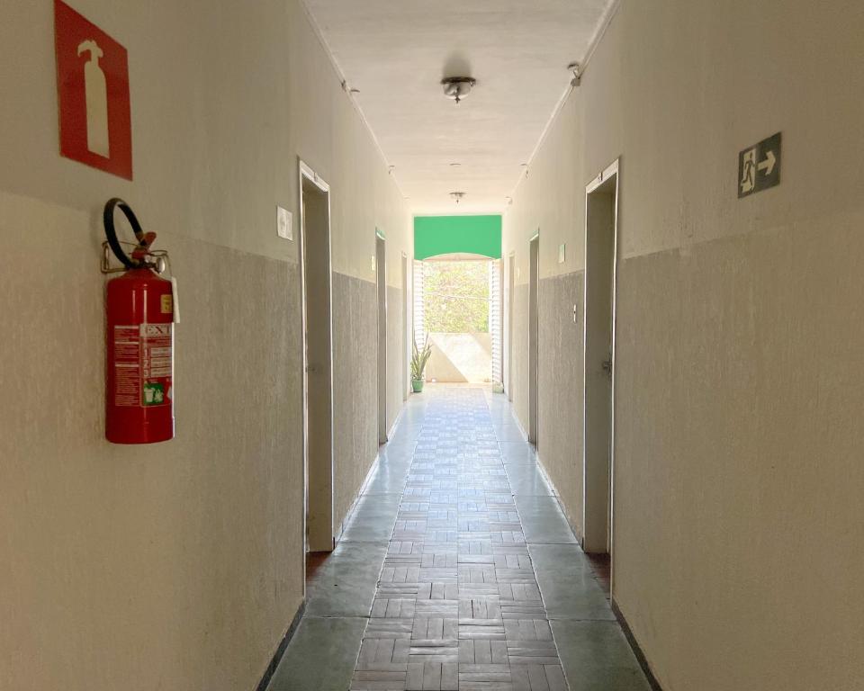 a hallway with a fire extinguisher on the wall at Elite Economy Hotel in Pará de Minas