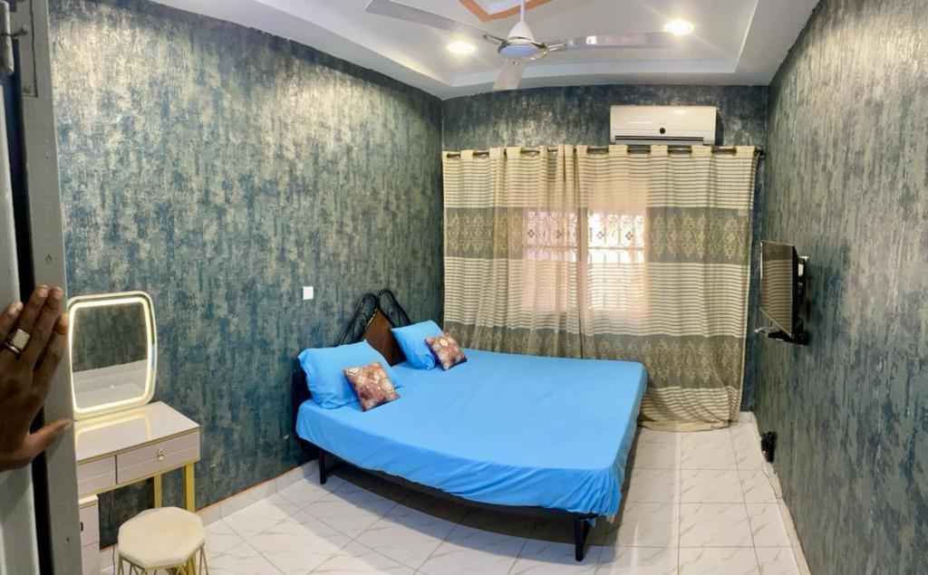 - une chambre avec un lit bleu dans l'établissement Seïf Industry's, à Ouagadougou