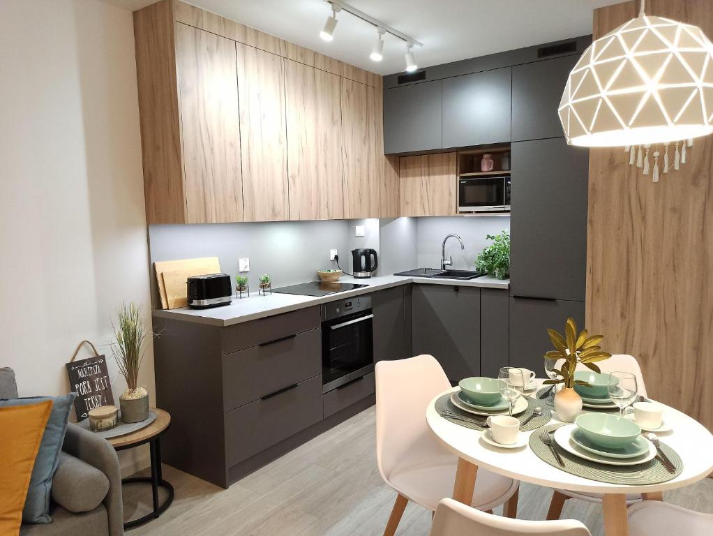 a kitchen and dining room with a table and chairs at Apartament Grabówek in Gdynia