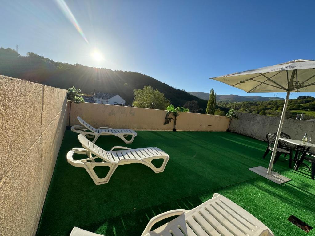 - une terrasse avec 2 chaises, une table et un parasol dans l'établissement Triacastela Sunset Terrace, à Tríacastela