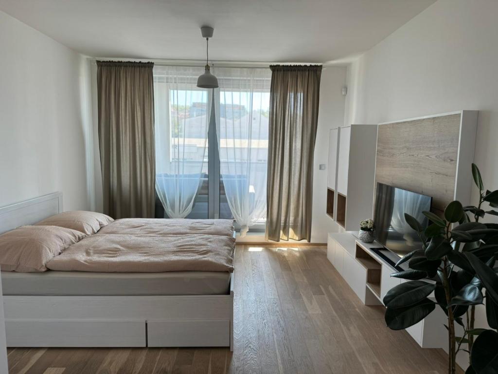 sypialnia z łóżkiem i dużym oknem w obiekcie O2 Arena Holliday suites w Pradze