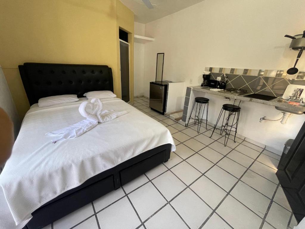 1 dormitorio con 1 cama con arco blanco en Hotel and Bungalows Palaces, en San Patricio Melaque
