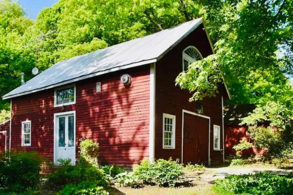 una pequeña casa de ladrillo rojo con puerta blanca en Charming barn in the heart of the Berkshires en New Marlborough