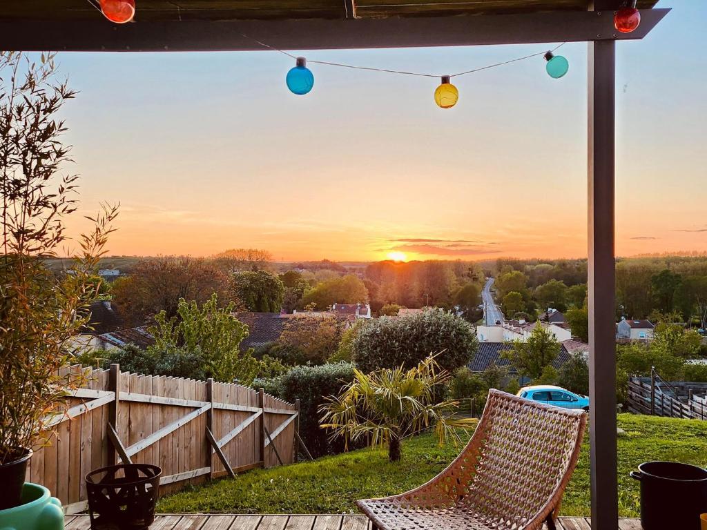 - une terrasse avec 2 chaises et le coucher du soleil dans l'établissement La Villa Ady Futuroscope 2 à 6 PERS, à Chasseneuil-du-Poitou
