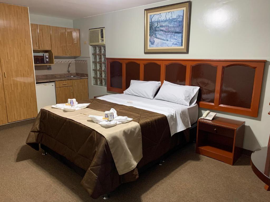 a bedroom with a large bed with two towels on it at Grand Hotel Betsy in Lima