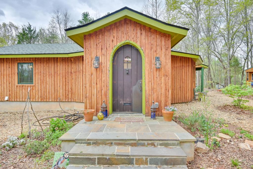uma casa de madeira com uma porta num quintal em Enchanting Shelby Cottage on 12 Acres and Hot Tub! em Shelby