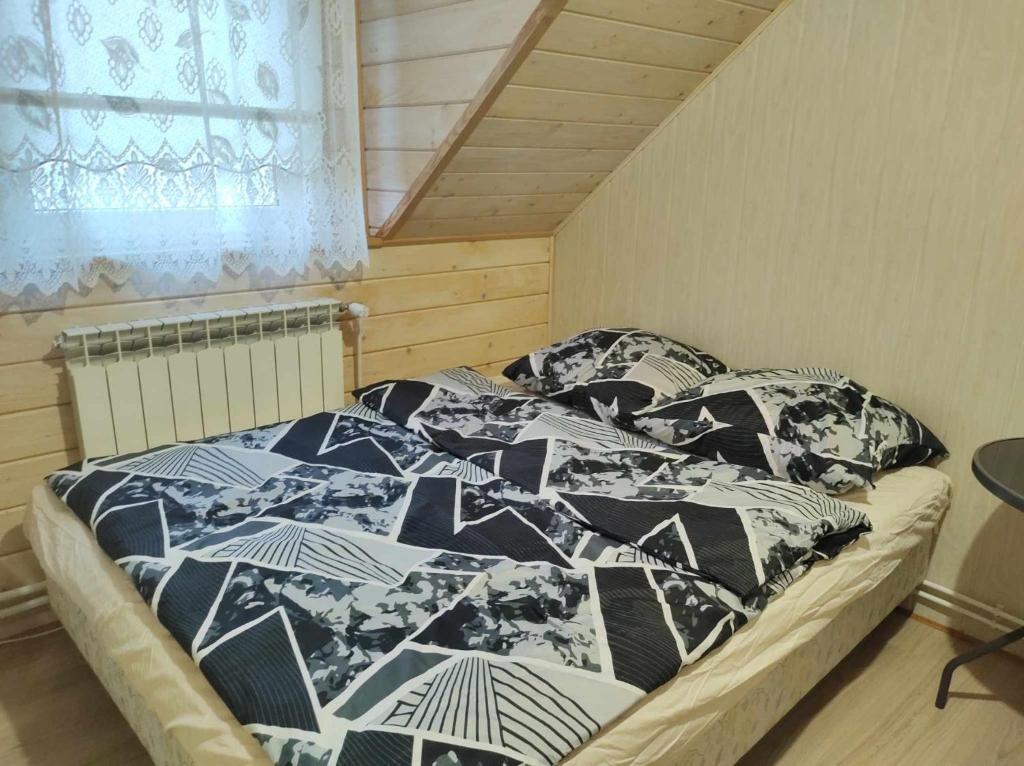 - un lit avec des couvertures et des oreillers noirs et blancs dans l'établissement Pokoje z łazienkami nad Jeziorem Serwy, à Mołowiste