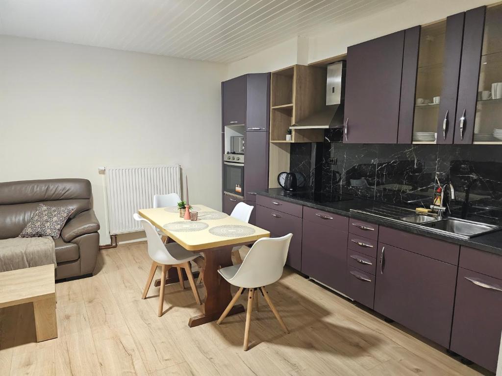 cocina con armarios morados, mesa y sillas en Neu Modernisiert Work and Stay top moderne 3 Zimmer Wohnung 5 Betten, en Geilenkirchen