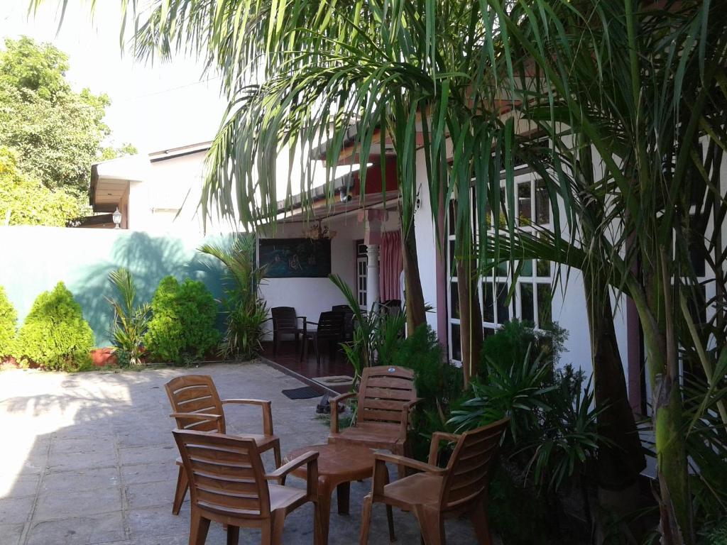 波隆納魯沃的住宿－迪爾珊旅館酒店，一组椅子和一张桌子,位于房子前面