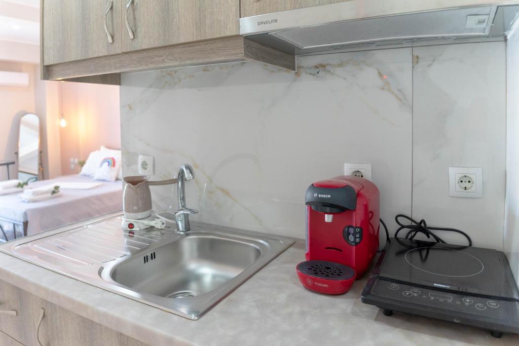 blat kuchenny ze zlewem i czerwonym urządzeniem w obiekcie Levanda Luxury Studios Apartments w mieście Nydri