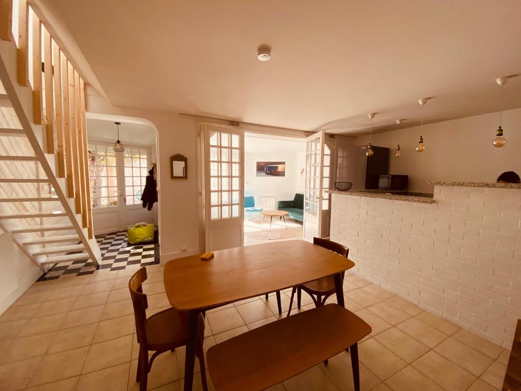 Maison le havre des marées في كابورغ: مطبخ وغرفة طعام مع طاولة خشبية