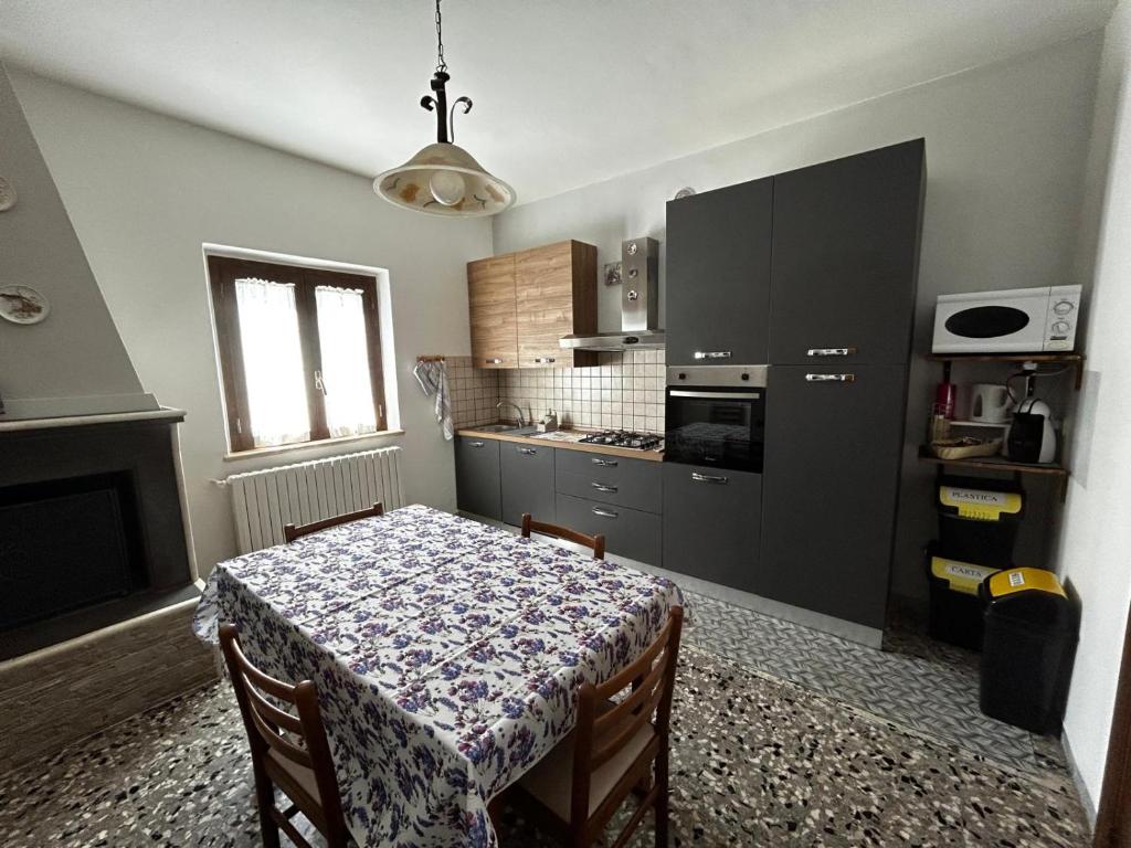 a kitchen with a table and a kitchen with a table and chairs at La lavanda in Controguerra