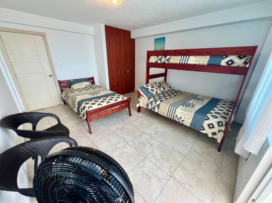 um quarto com duas camas e uma mesa e cadeiras em Departamento Arena Tonsupa em Volcán Chimborazo