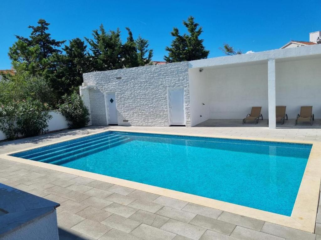 a swimming pool in the backyard of a house at Villa Sunny Day Sendi Deluxe Novalja in Novalja