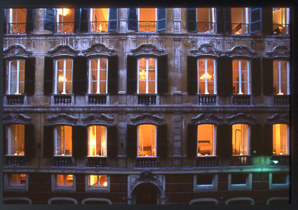 un edificio alto con ventanas iluminadas por la noche en Palazzo Cicala, en Génova