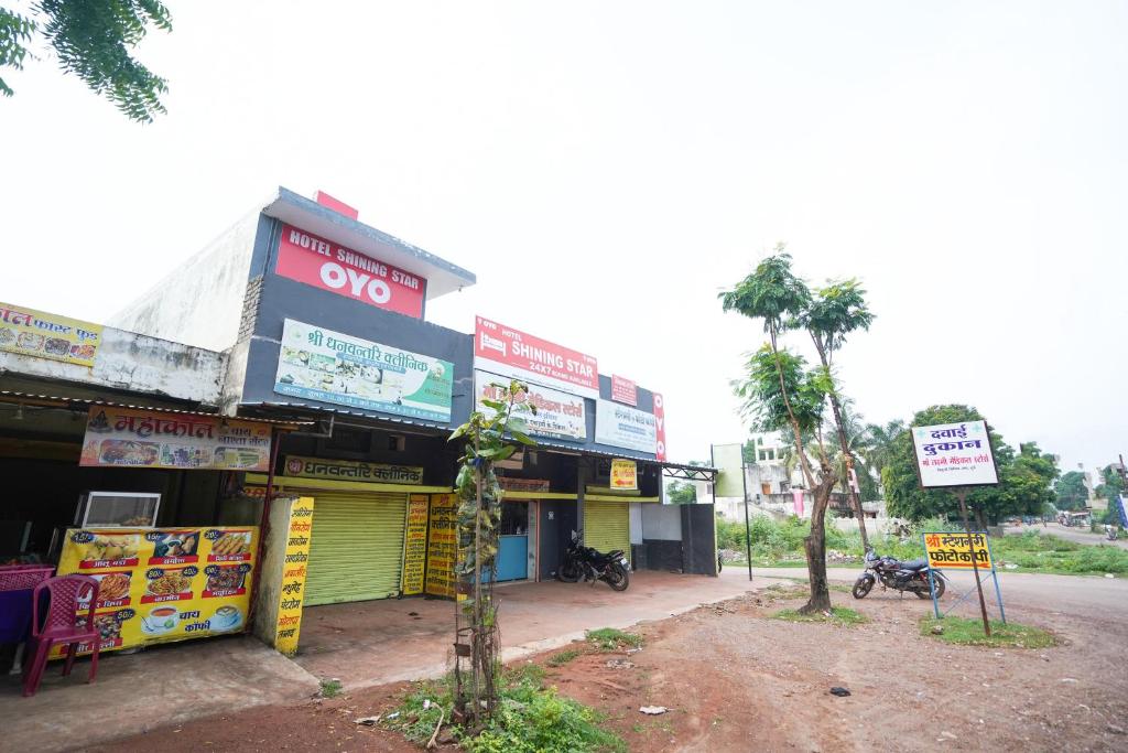 een gebouw met borden aan de straatkant bij OYO Hotel Shining Star in Bhilai