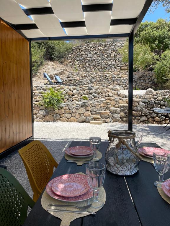 una mesa negra con platos y vasos en un patio en Sougia Glamping, en La Canea
