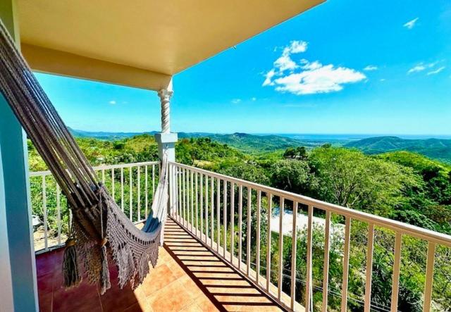 a hammock on a balcony with a view of the mountains at Camino Al Cielo in Guayanilla