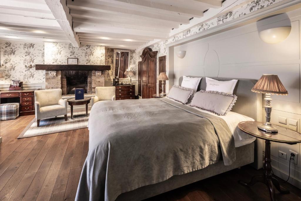 um quarto com uma cama grande e uma lareira em Hotel De Orangerie by CW Hotel Collection em Bruges