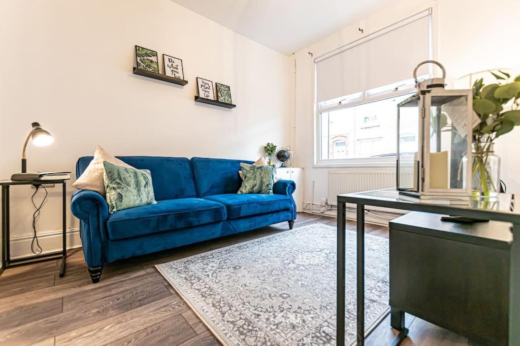 a living room with a blue couch and a table at Liverpool city centre house, Free parking in Liverpool