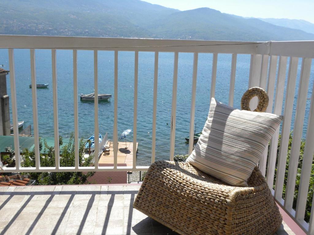a rattan chair sitting on a balcony overlooking the ocean at Apartments Kanevce Beach&Relax in Ohrid